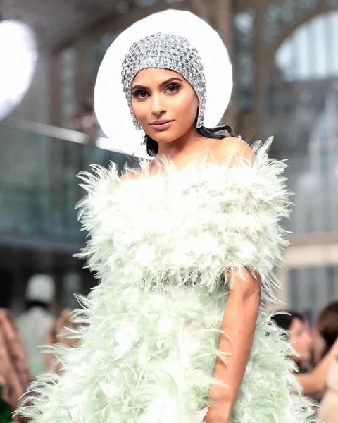 Runway beauty with a crystal cap and feathered couture — fashion week makeup